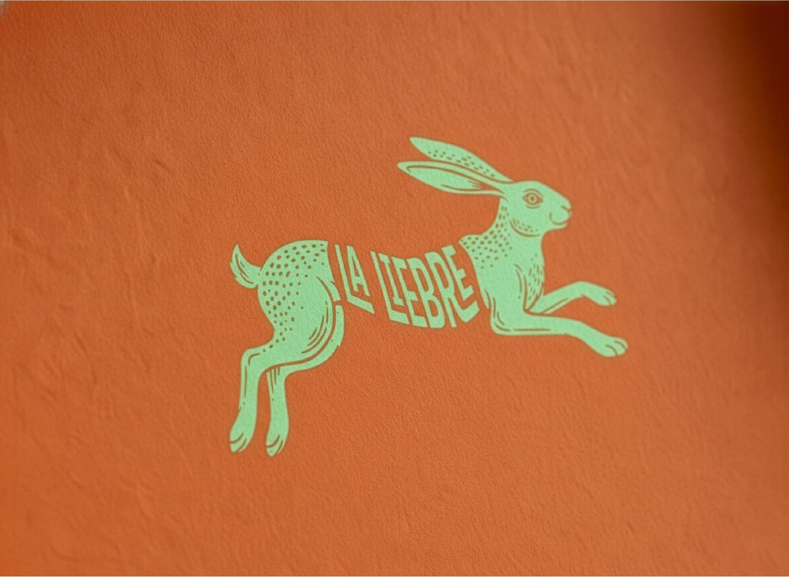 Liebre saltando aislada sobre fondo naranja, ilustración de trazo limpio en verde menta