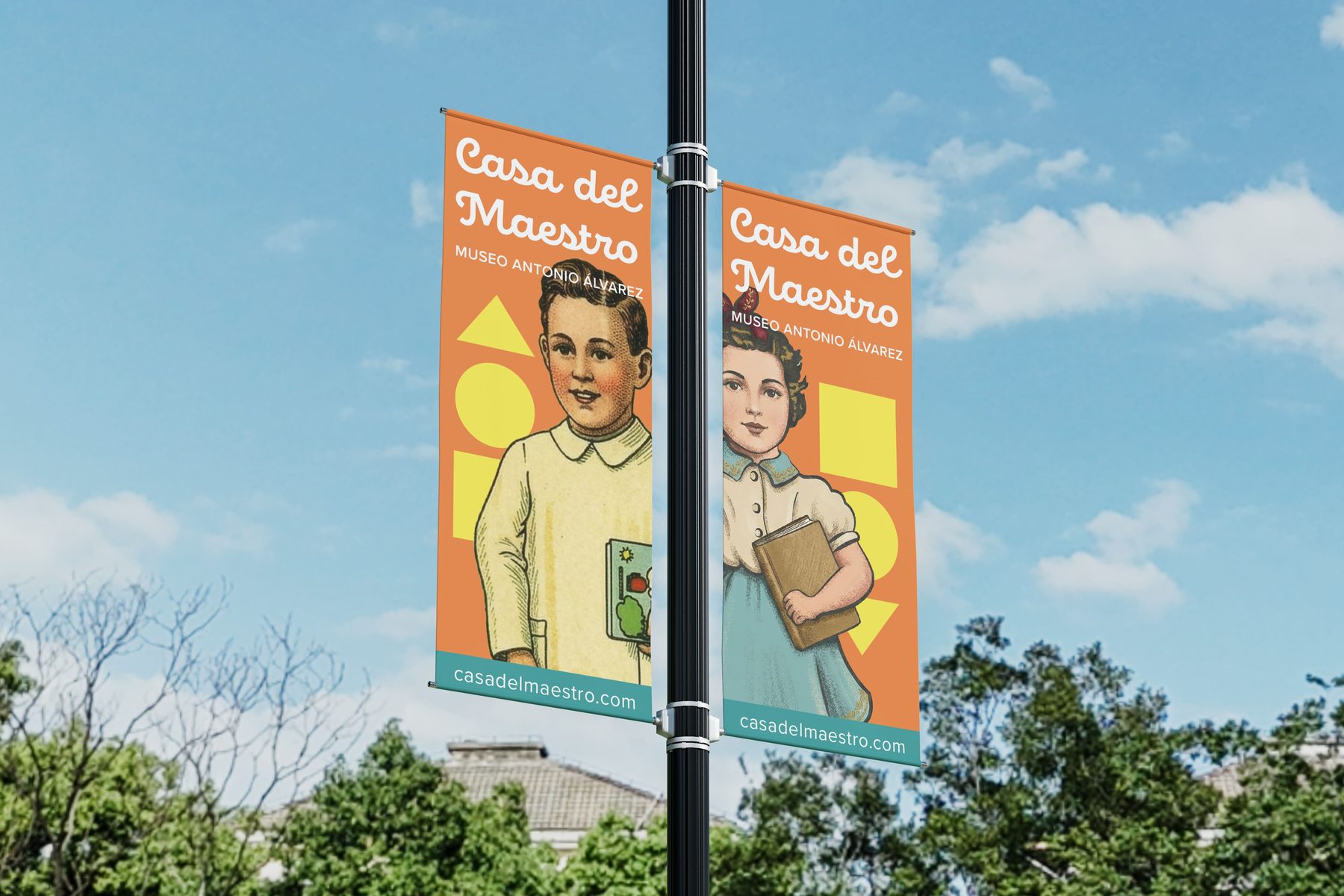 Dos banderolas verticales colgadas de farola contra cielo despejado con árboles al fondo, cada una con un personaje ilustrado distinto —niño con cuaderno y niña con libro— sobre fondo naranja con formas geométricas amarillas