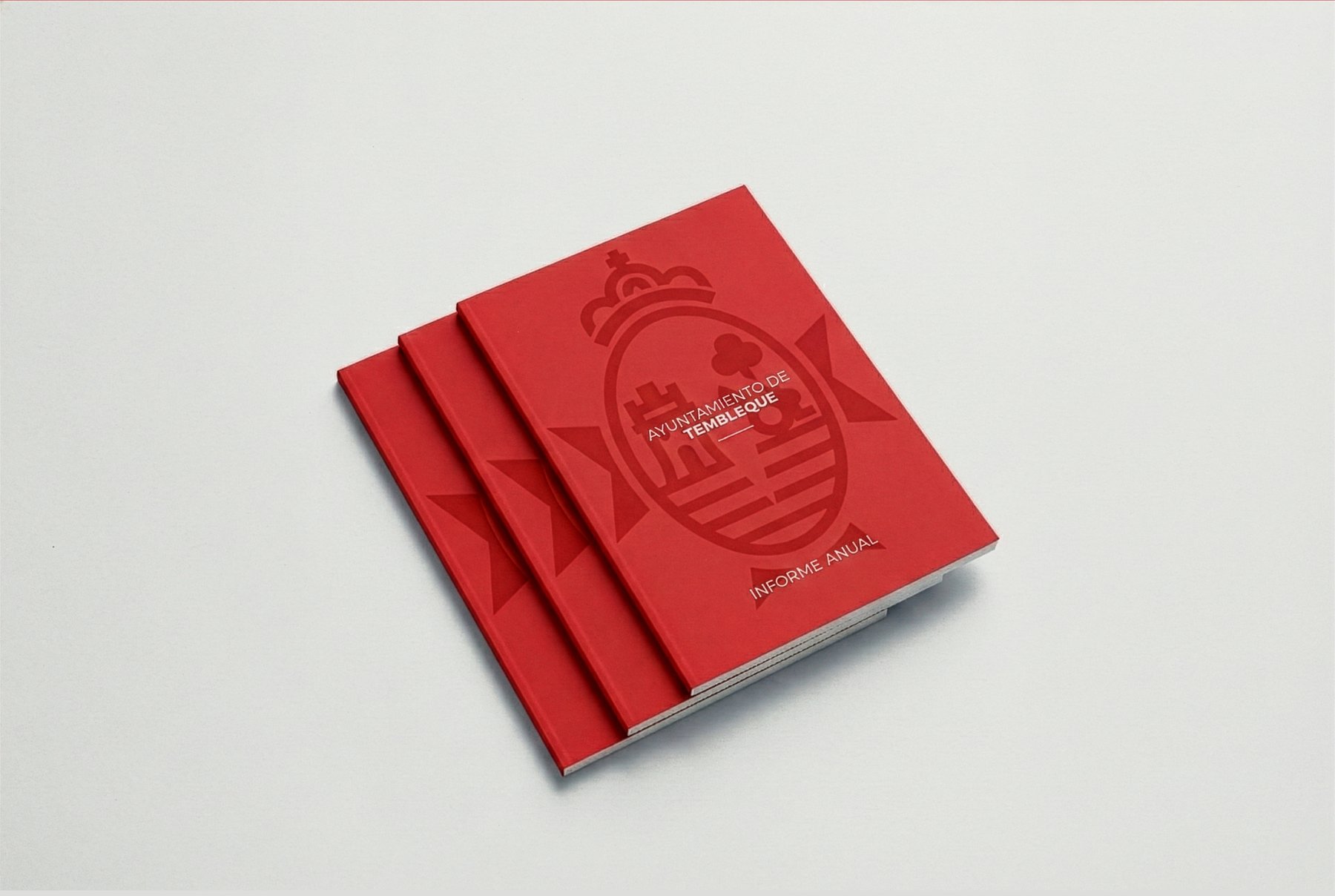 Dos libretas tipo Moleskine en cartoné rojo apiladas, con el escudo y la palabra «Tembleque» grabados en seco sobre la cubierta