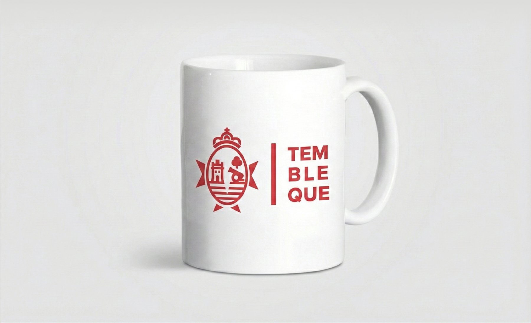 Taza blanca con la palabra TEM/BLE/QUE partida en tres líneas y el escudo aplicado a un lado en rojo